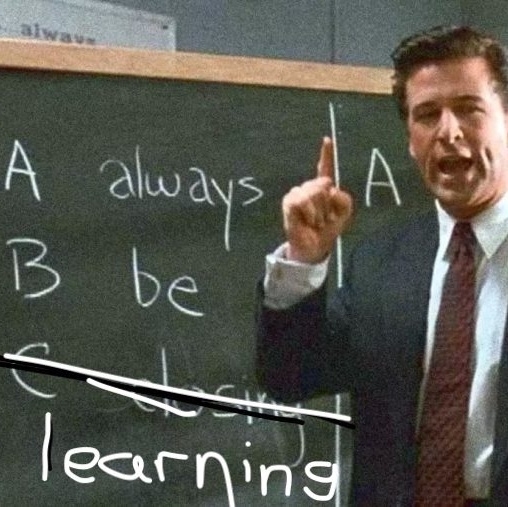 A scene from the film Glengarry Glen Ross. Alec Baldwin in front of a blackboard.